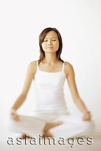 Asia Images Group - Young woman sitting in lotus position, eyes closed