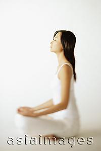 Asia Images Group - Young woman sitting on floor, profile
