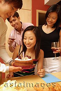 Asia Images Group - Woman looking at cake, surrounded by friends