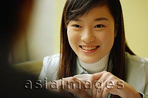 Asia Images Group - Young woman holding teacup, looking forward