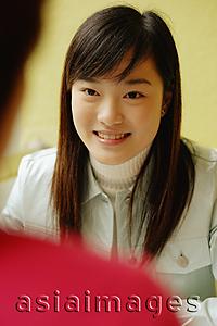 Asia Images Group - Young woman facing another person, smiling