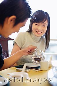 Asia Images Group - Young man pouring tea for young woman