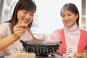 Asia Images Group - Young women having soup at restaurant