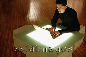 Asia Images Group - Young man using laptop on lightbox table