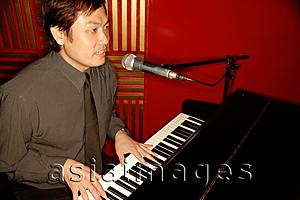 Asia Images Group - Man singing and playing the piano
