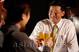 Asia Images Group - Two men toasting with beer.