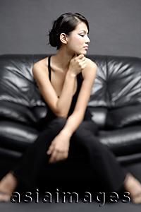 Asia Images Group -  Young woman on chair, looking away
