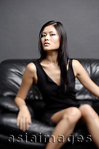 Asia Images Group -  Young woman on chair, looking at camera