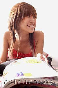 Asia Images Group - Young woman with magazine, smiling