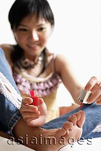 Asia Images Group - Woman painting her toenails