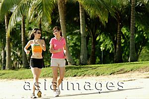 Asia Images Group - Two women jogging along beach, side by side