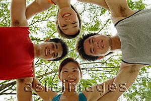 Asia Images Group - Two women and two men, arms around each other looking down at camera