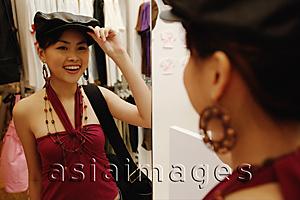 Asia Images Group - Young woman trying on beret, looking in mirror