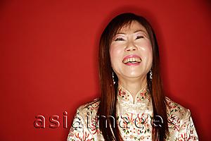 Asia Images Group - Mature woman in cheongsam, laughing