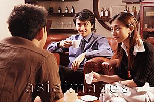 Asia Images Group - Couple having coffee, facing another man