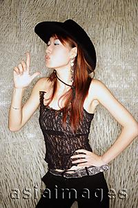 Asia Images Group - Young woman, hands on hip, wearing cowboy hat