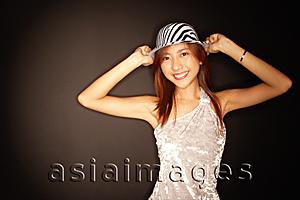 Asia Images Group - Young woman with hat, hands on head
