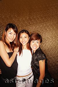 Asia Images Group - Young women arms around each other, smiling at camera