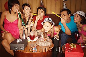 Asia Images Group - Young adults celebrating with noisemakers and party hats