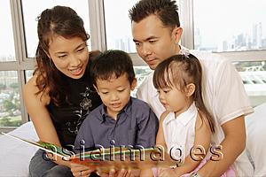 Asia Images Group - Family with two children sitting together, looking at book