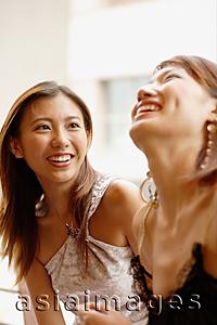 Asia Images Group -  Young women side by side, smiling and laughing