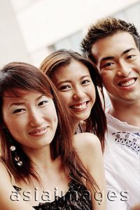 Asia Images Group - Two young women and one young man, looking at camera, smiling