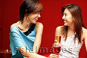 Asia Images Group - Two young women, with drinks, facing each other