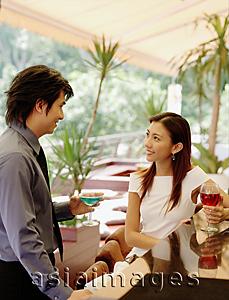 Asia Images Group - Couple at bar counter, with drinks