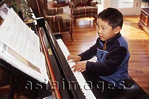 Asia Images Group - Boy playing the piano.