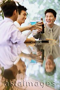 Asia Images Group - Young men raising drinks for a toast