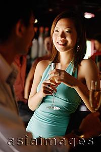 Asia Images Group - Couple with champagne glasses, talking