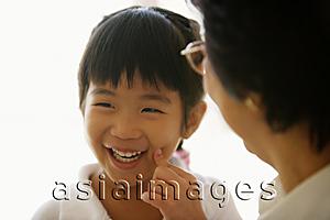 Asia Images Group - Granddaughter with finger on cheek, grandmother in front of her