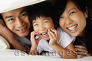 Asia Images Group - Couple with young daughter under sheets