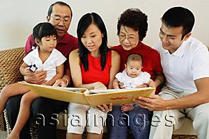 Asia Images Group - Three generation family, looking at photo album