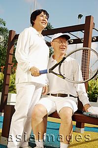 Asia Images Group - Woman holding tennis racket, man sitting next to her