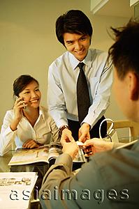 Asia Images Group - Executives having a discussion, woman using mobile phone