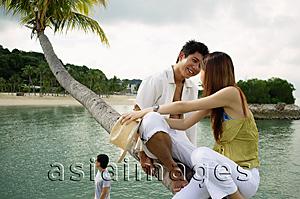 Asia Images Group - Couple sitting on tree, face to face