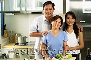 Asia Images Group - Family with adult offspring, standing in kitchen