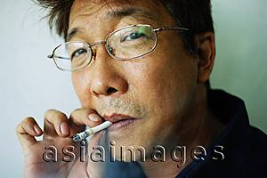 Asia Images Group - Man smoking cigarette, headshot