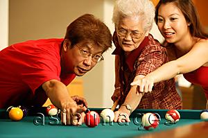 Asia Images Group - Father and daughter teaching grandmother to play pool