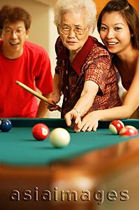Asia Images Group - Father and daughter teaching grandmother to play pool