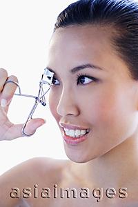 Asia Images Group - Headshot of woman using eyelash curler