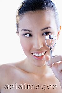 Asia Images Group - Woman using eyelash curler