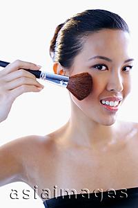 Asia Images Group - Woman applying make-up with brush