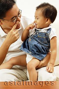Asia Images Group - Father holding young daughter, both touching their noses