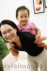 Asia Images Group - Mother carrying daughter on back