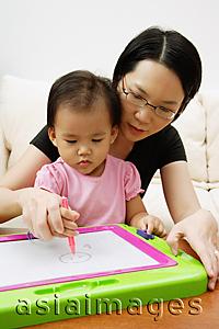 Asia Images Group - Mother teaching daughter to draw