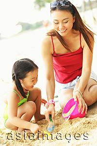 Asia Images Group - Mother with one child on beach, playing with sand