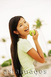 Asia Images Group - Woman with apple, looking at camera