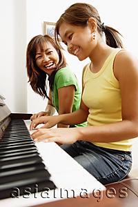 Asia Images Group - Mother and daughter sitting side by side in front of piano
